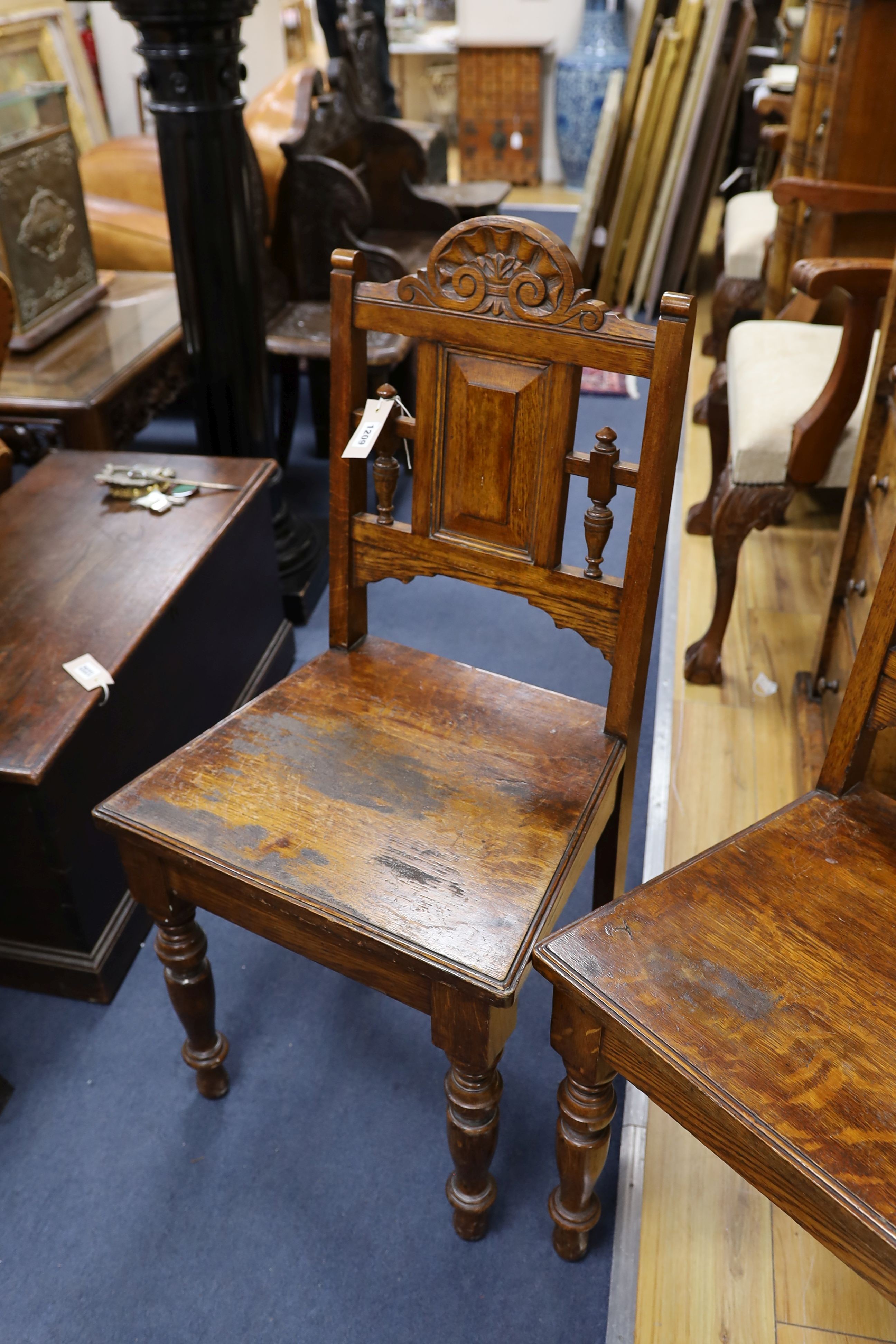 A pair of Victorian carved oak hall chairs